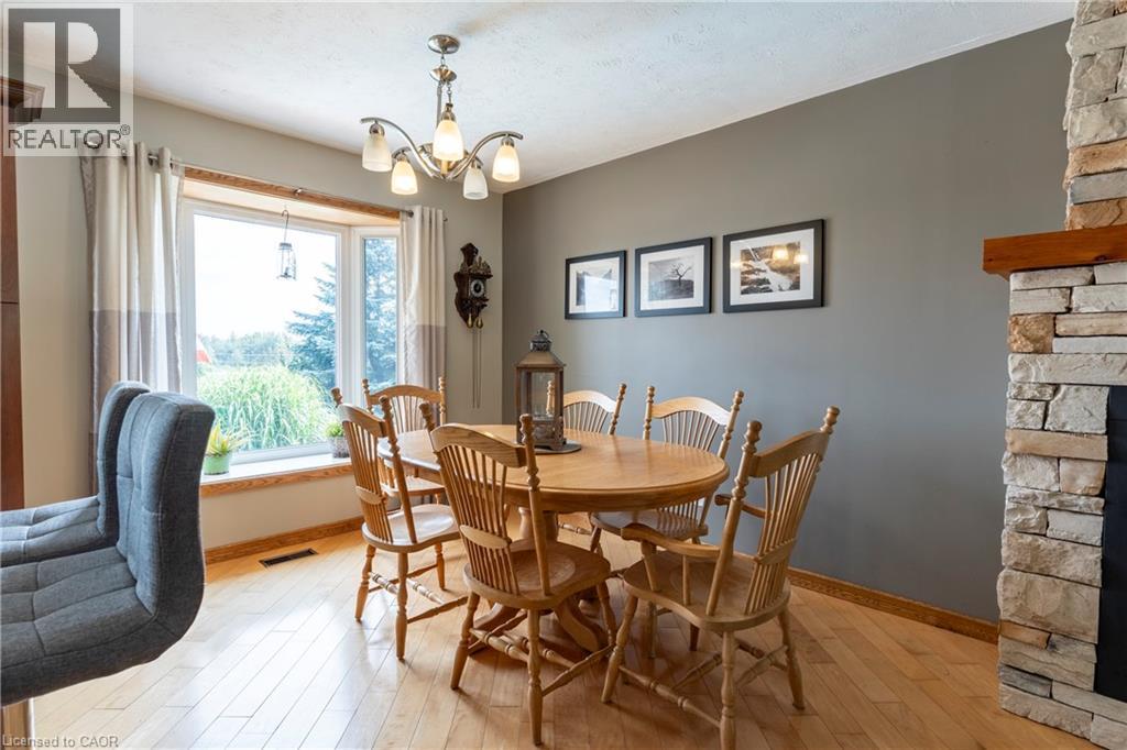 Dining area featuring light wood-style floors, a fireplace, and a chandelier - 29 Armstrong Crescent, Grey Highlands, ON - Indoor Photo Showing Dining Room