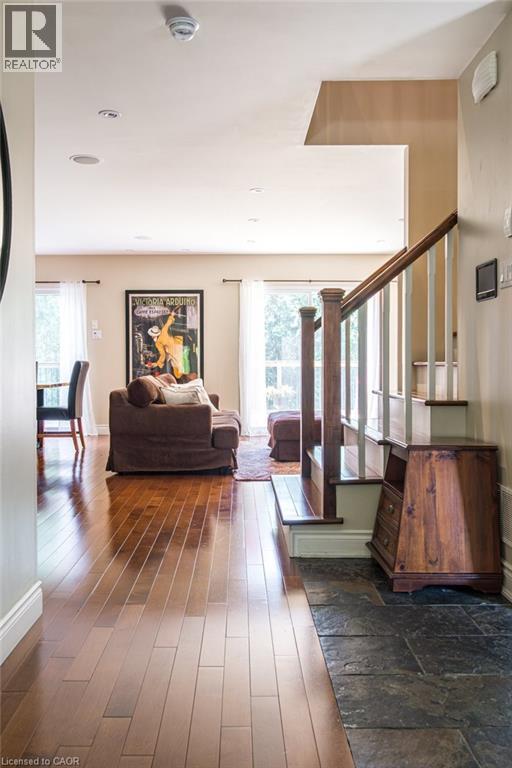Living area featuring healthy amount of natural light, wood-type flooring, stairway, and baseboards - 330 Strathcona Drive, Burlington, ON - Indoor