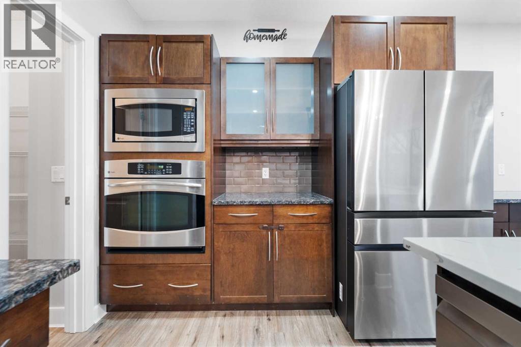 Chef-inspired kitchen with built-in oven and quality stainless steel appliances. - 70 Royal Ridge Manor Nw, Calgary, AB - Indoor Photo Showing Kitchen With Upgraded Kitchen