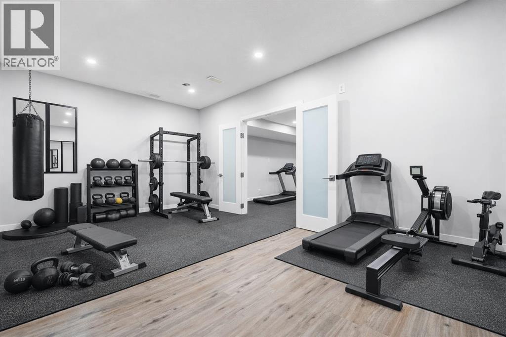 The spacious basement room is suitable for use as a gym or secondary office. - 70 Royal Ridge Manor Nw, Calgary, AB - Indoor Photo Showing Gym Room