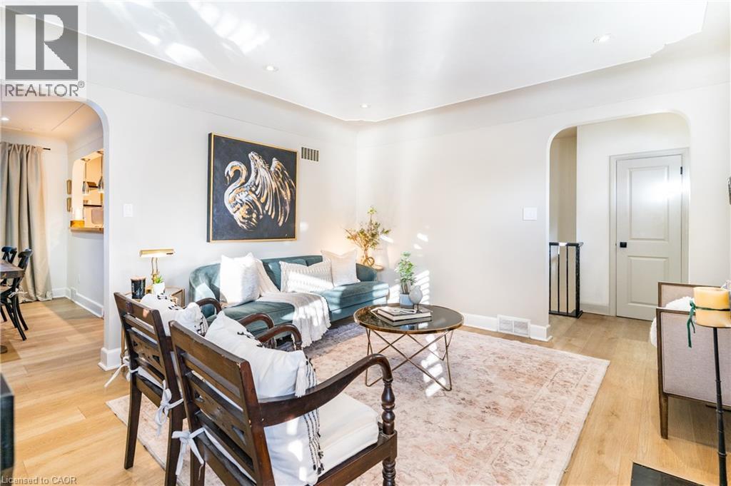 Living area featuring arched walkways, light wood-style flooring, and recessed lighting - 3 Fallsview Road, Hamilton, ON - Indoor Photo Showing Living Room