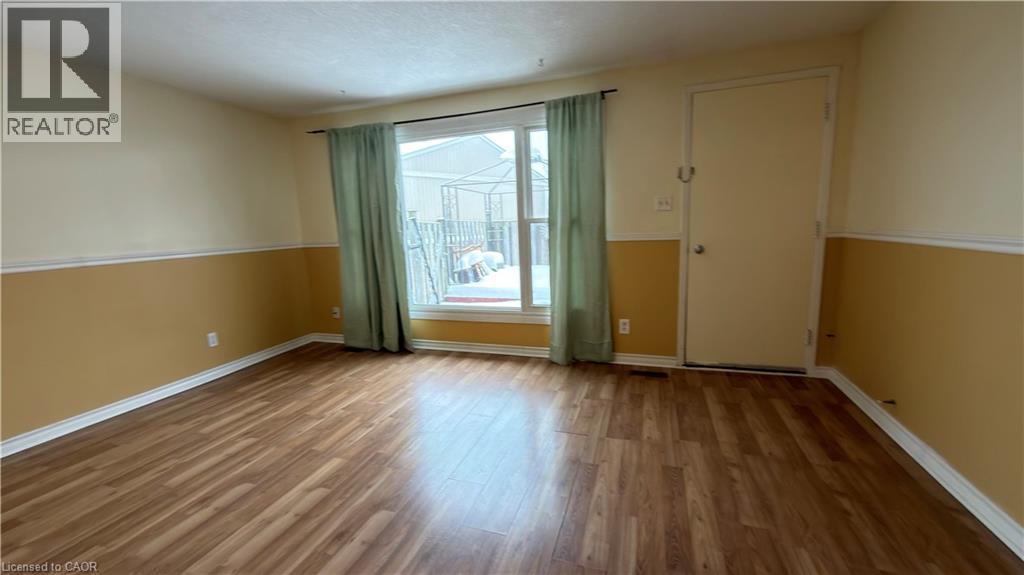 Unfurnished room with wood finished floors and baseboards - 66 Glamis Road Unit# 33, Cambridge, ON - Indoor Photo Showing Other Room
