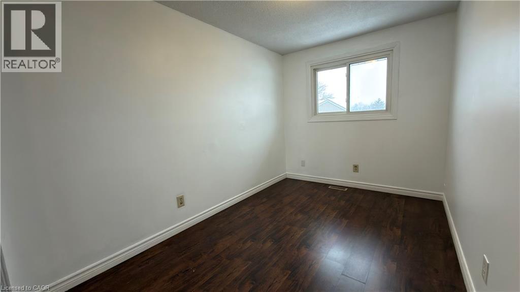 Empty room with dark wood finished floors and baseboards - 66 Glamis Road Unit# 33, Cambridge, ON - Indoor Photo Showing Other Room
