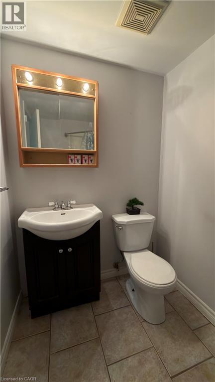 Half bath with vanity and light tile patterned floors - 66 Glamis Road Unit# 33, Cambridge, ON - Indoor Photo Showing Bathroom
