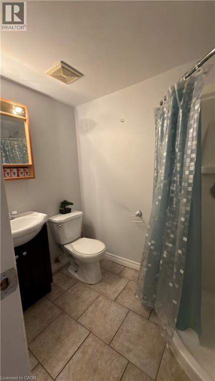 Bathroom featuring a shower with shower curtain, vanity, and light tile patterned floors - 66 Glamis Road Unit# 33, Cambridge, ON - Indoor Photo Showing Bathroom
