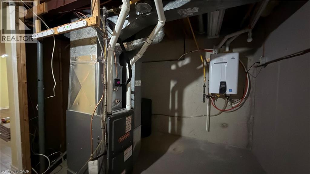 Utilities featuring heating unit and tankless water heater - 66 Glamis Road Unit# 33, Cambridge, ON - Indoor Photo Showing Basement