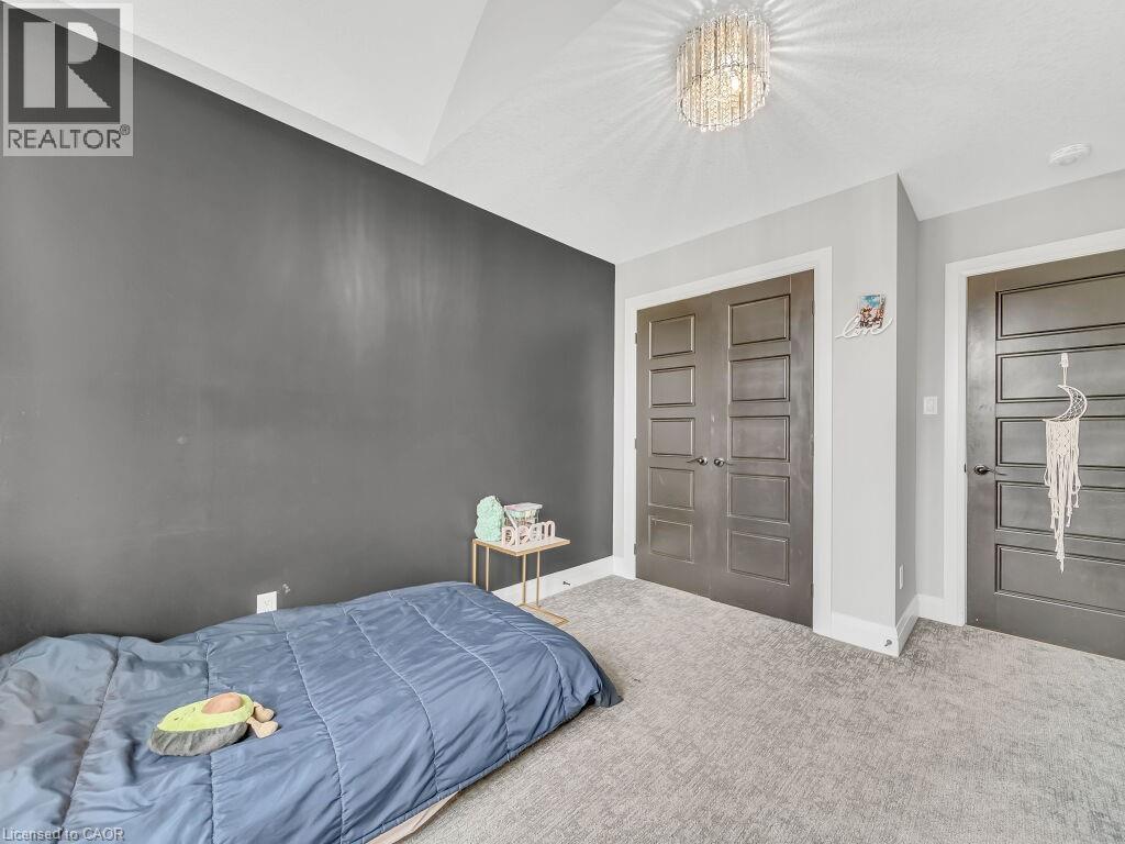 Carpeted bedroom with a chandelier and a closet - 3374 Oriole Drive, London, ON - Indoor Photo Showing Bedroom