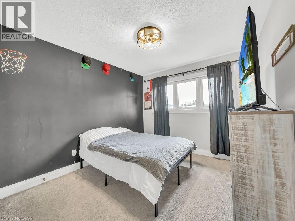 Carpeted bedroom featuring a textured ceiling and baseboards - 3374 Oriole Drive, London, ON - Indoor Photo Showing Bedroom