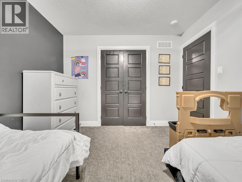 Bedroom with light colored carpet, a textured ceiling, and a closet - 3374 Oriole Drive, London, ON - Indoor Photo Showing Bedroom