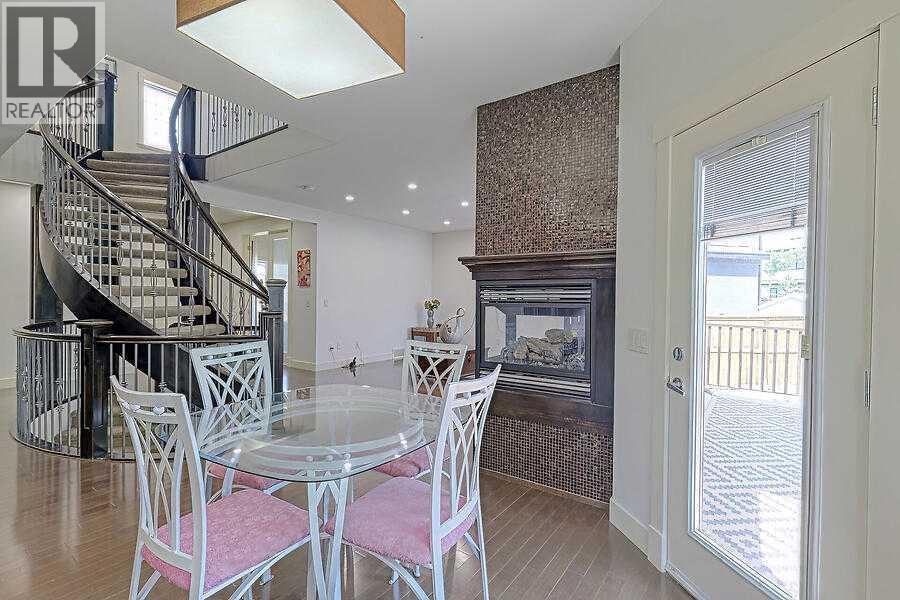 16 Rockcliff Point Nw, Calgary, AB - Indoor Photo Showing Dining Room With Fireplace