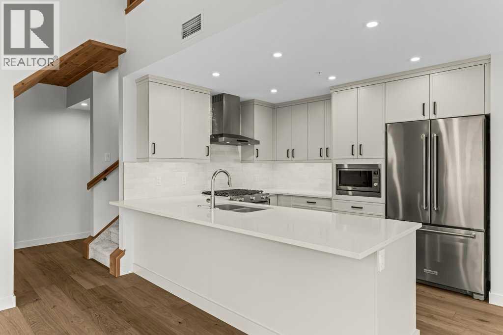 407, 1505 Spring Creek Gate, Canmore, AB - Indoor Photo Showing Kitchen With Double Sink With Upgraded Kitchen