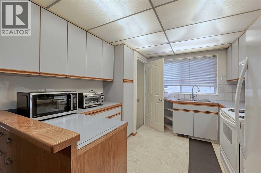 28 7 Avenue Se, High River, AB - Indoor Photo Showing Kitchen With Double Sink