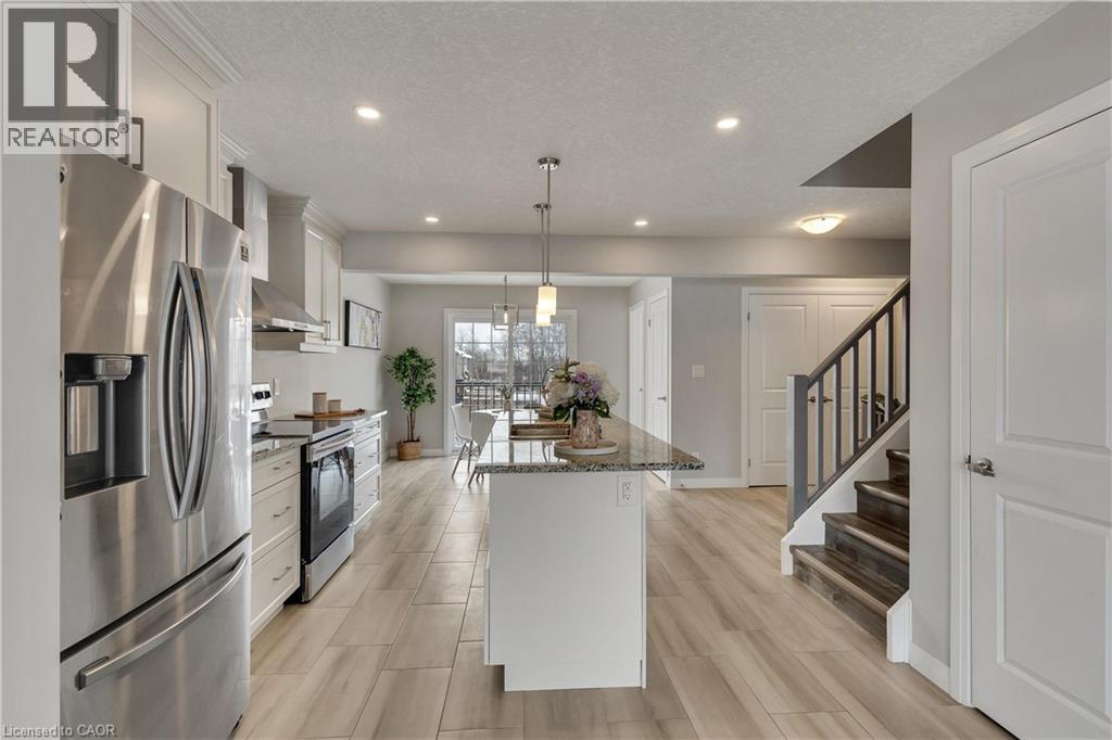 Kitchen featuring dark stone countertops, appliances with stainless steel finishes, white cabinetry, a kitchen island, and recessed lighting - 492 Wismer Street, Waterloo, ON - Indoor Photo Showing Kitchen With Stainless Steel Kitchen With Upgraded Kitchen