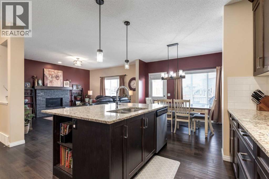 26 Mount Rae Terrace, Okotoks, AB - Indoor Photo Showing Kitchen With Fireplace With Double Sink With Upgraded Kitchen