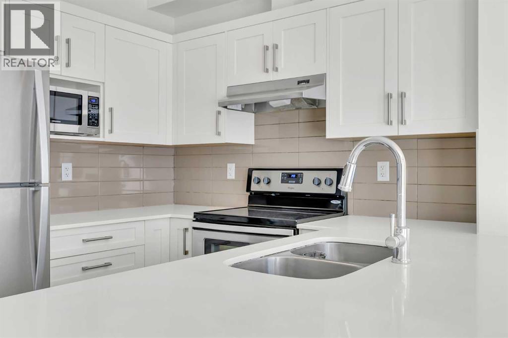 211, 10 Walgrove Walk Se, Calgary, AB - Indoor Photo Showing Kitchen With Stainless Steel Kitchen With Double Sink With Upgraded Kitchen