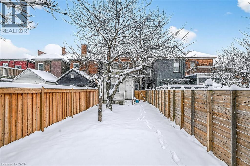 Snowy yard with a fenced backyard and a storage shed - 77 Barton Street E Unit# 1, Hamilton, ON - Outdoor