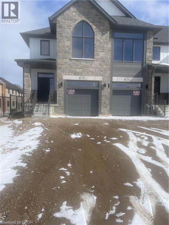 View of front facade with stone siding, an attached garage, and driveway - 152 Queensbrook Crescent, Cambridge, ON - Outdoor With Facade