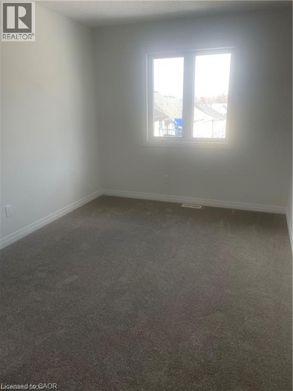 Empty room featuring dark carpet and baseboards - 152 Queensbrook Crescent, Cambridge, ON - Indoor Photo Showing Other Room