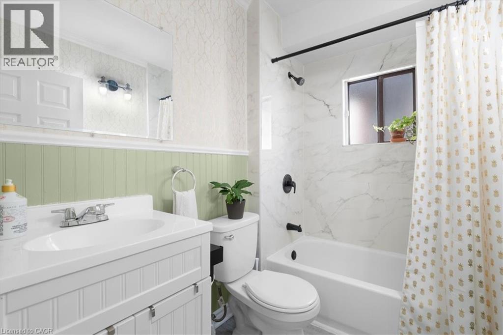 Bathroom with vanity, a wainscoted wall, and shower / bathtub combination with curtain - 133 Frederick Avenue, Hamilton, ON - Indoor Photo Showing Bathroom