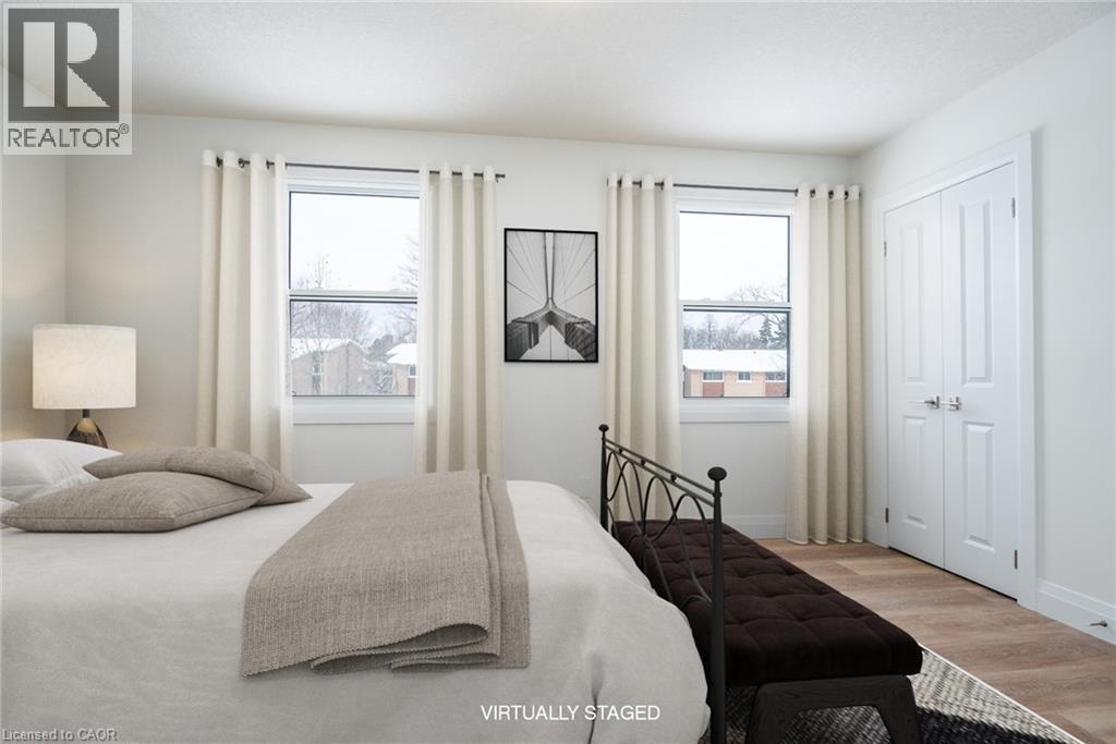Bedroom featuring wood finished floors, multiple windows, and a closet - 27 Queenston Drive, Kitchener, ON - Indoor Photo Showing Bedroom