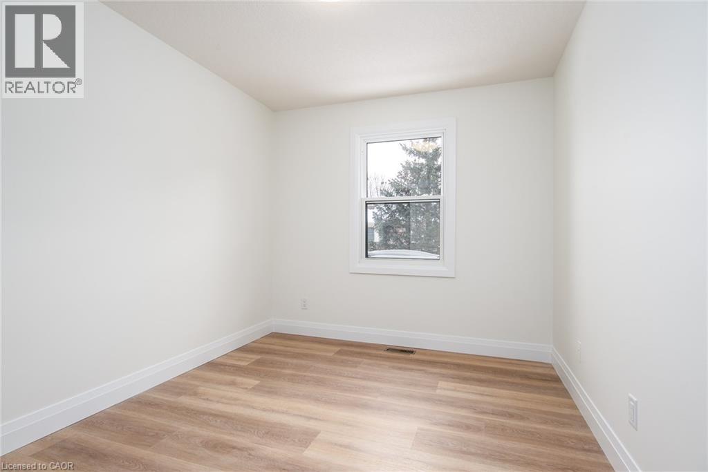 Empty room with light wood-style flooring and baseboards - 27 Queenston Drive, Kitchener, ON - Indoor Photo Showing Other Room