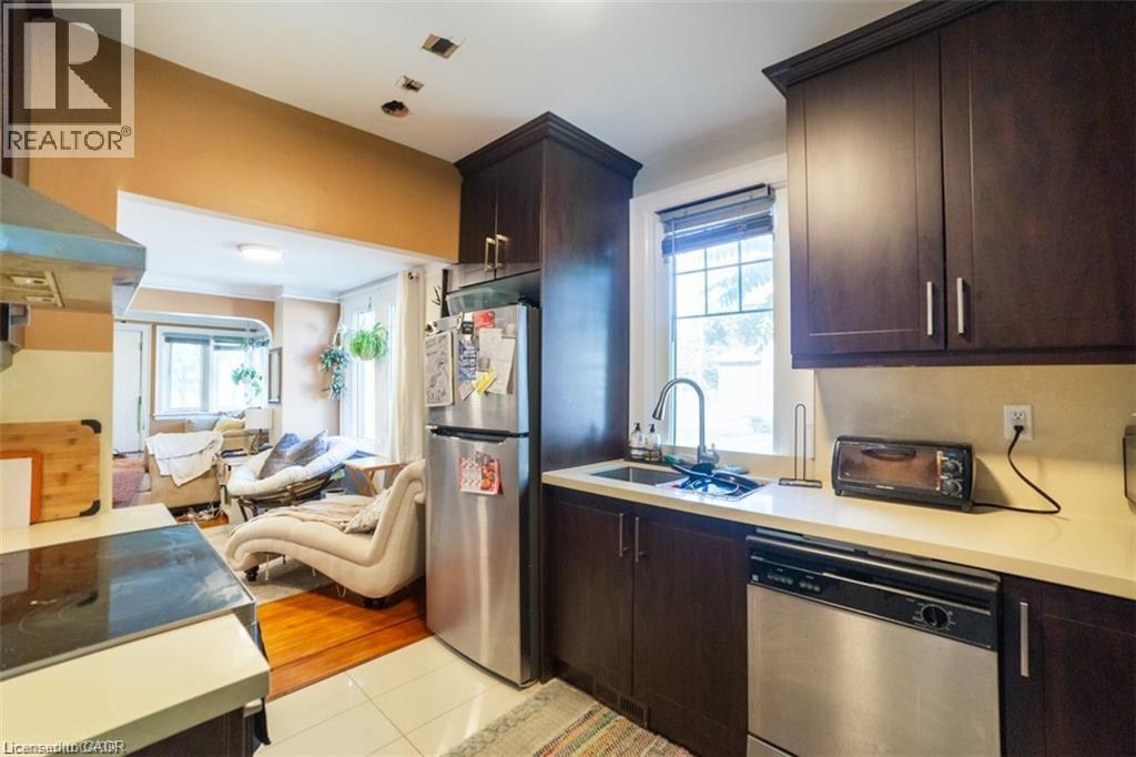 Kitchen featuring dark brown cabinetry, appliances with stainless steel finishes, and light countertops - 41 Paradise Road S, Hamilton, ON - Indoor Photo Showing Kitchen