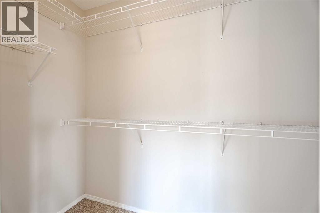 large walk-in closet in primary bedroom - 122 Panamount Drive Nw, Calgary, AB - Indoor With Storage