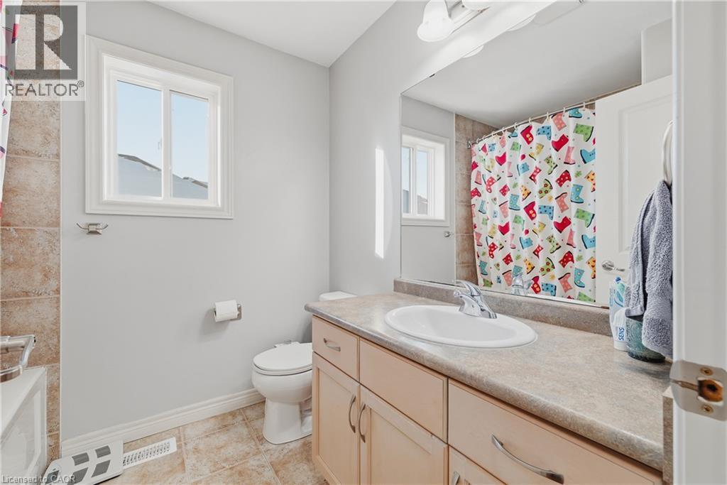 Full bathroom with vanity, a shower with shower curtain, a tub, and light tile patterned floors - 23 Doon Creek Street, Kitchener, ON - Indoor Photo Showing Bathroom