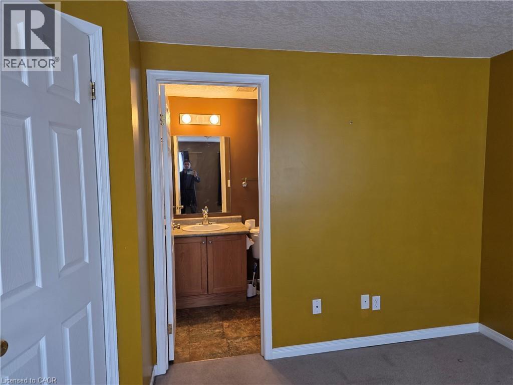 Corridor featuring dark colored carpet and a textured ceiling - 220 Snowdrop Crescent, Kitchener, ON - Indoor Photo Showing Other Room