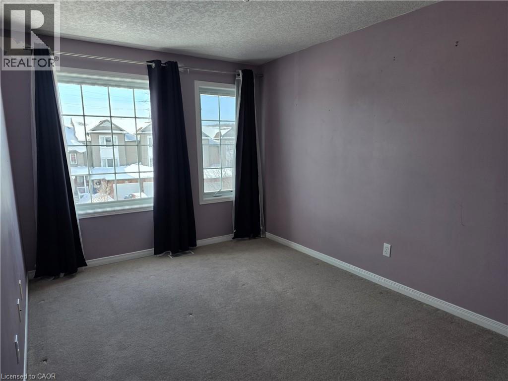 Spare room with a textured ceiling and carpet - 220 Snowdrop Crescent, Kitchener, ON - Indoor Photo Showing Other Room
