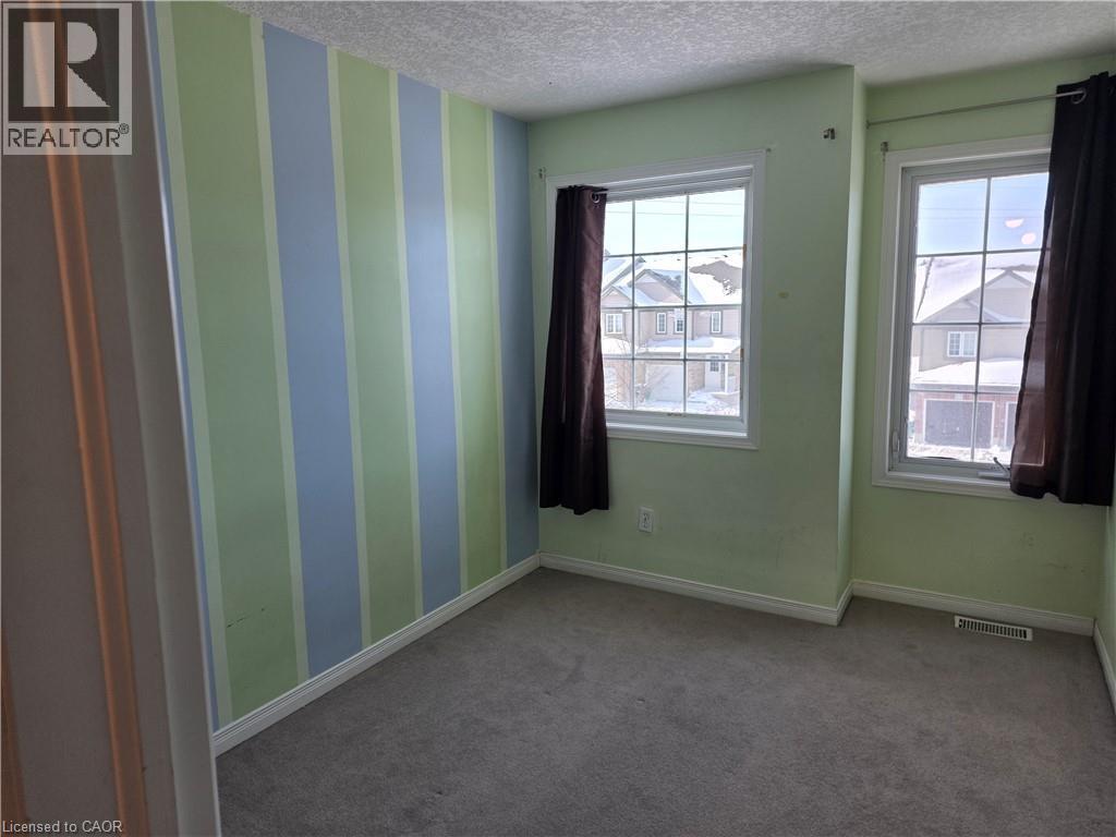 Empty room featuring carpet, a textured ceiling, and wallpapered walls - 220 Snowdrop Crescent, Kitchener, ON - Indoor Photo Showing Other Room
