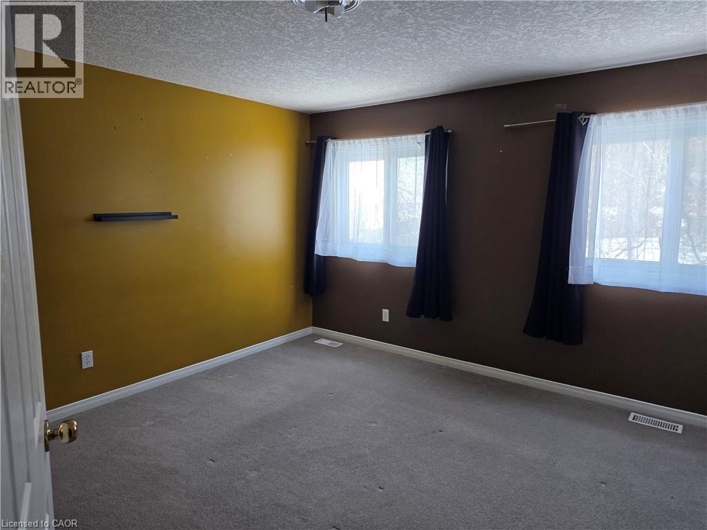 Spare room featuring a textured ceiling and carpet - 220 Snowdrop Crescent, Kitchener, ON - Indoor