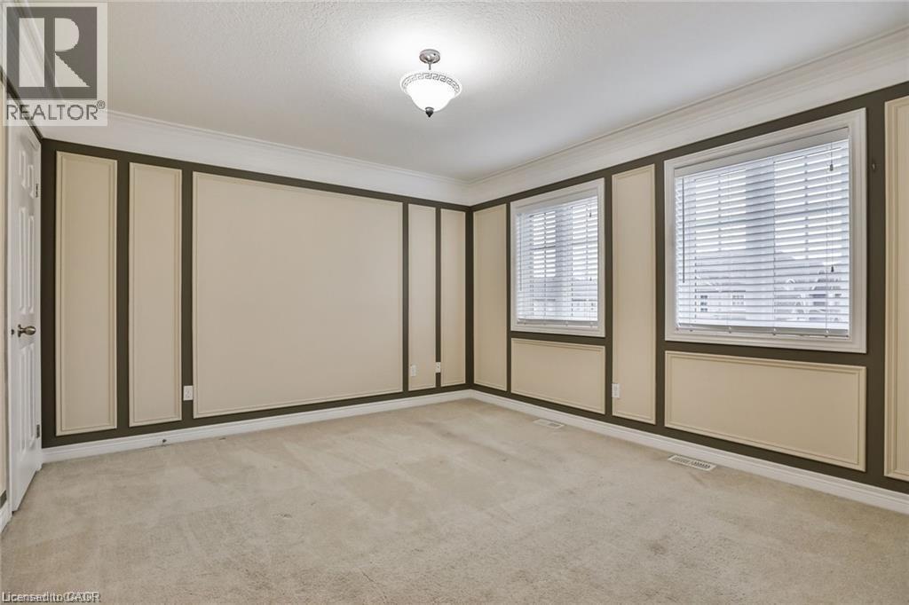 Empty room featuring light colored carpet, crown molding, and a decorative wall - 42 Madonna Drive, Hamilton, ON - Indoor Photo Showing Other Room