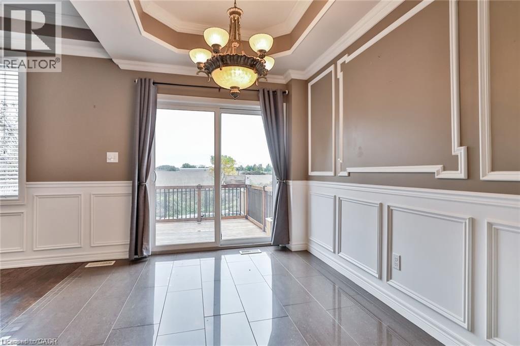 Unfurnished dining area with plenty of natural light, a decorative wall, suspended lighting, crown molding, and a wainscoted wall - 42 Madonna Drive, Hamilton, ON - Indoor Photo Showing Other Room