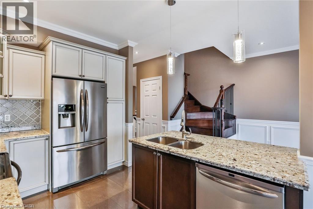 Kitchen featuring stainless steel appliances, pendant lighting, light stone counters, ornamental molding, and backsplash - 42 Madonna Drive, Hamilton, ON - Indoor Photo Showing Kitchen With Stainless Steel Kitchen With Double Sink With Upgraded Kitchen