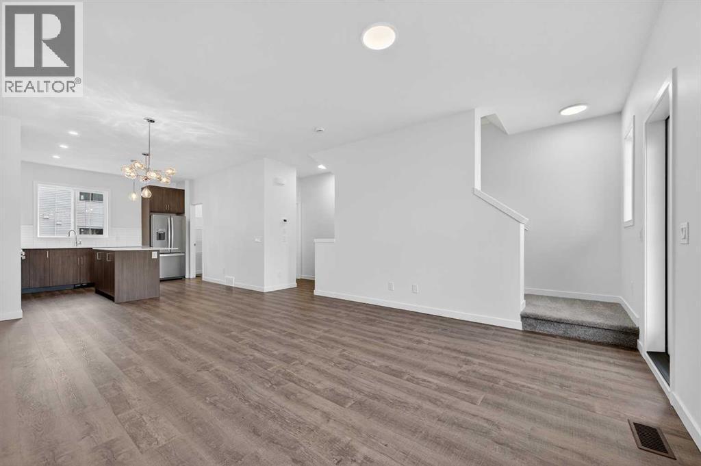 Open through living area/kitchen - 64 Creekside Drive Sw, Calgary, AB - Indoor Photo Showing Kitchen