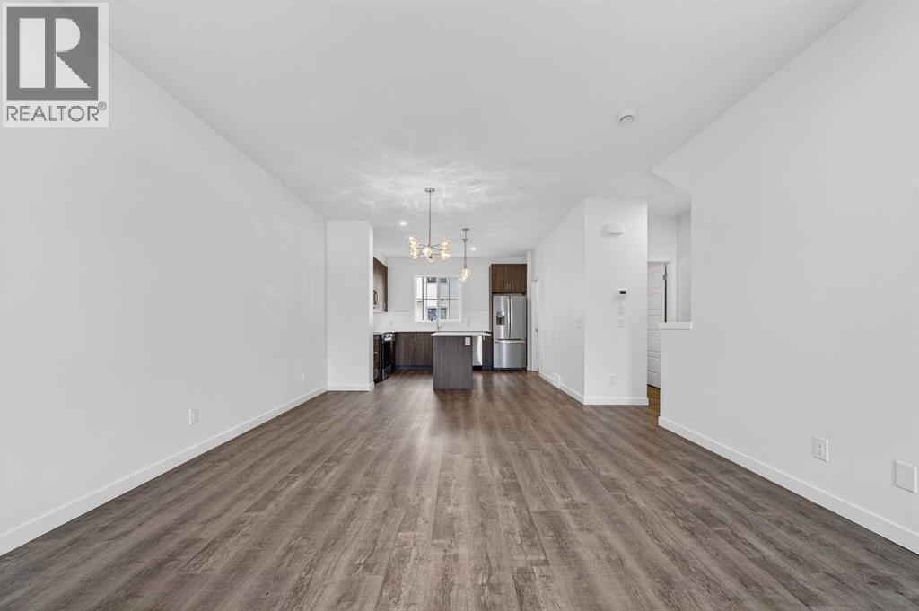 Open through living area/kitchen - 64 Creekside Drive Sw, Calgary, AB - Indoor