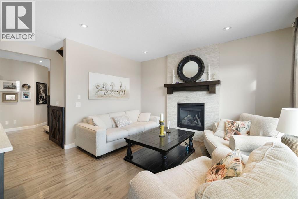 8 Emberside Glen, Cochrane, AB - Indoor Photo Showing Living Room With Fireplace