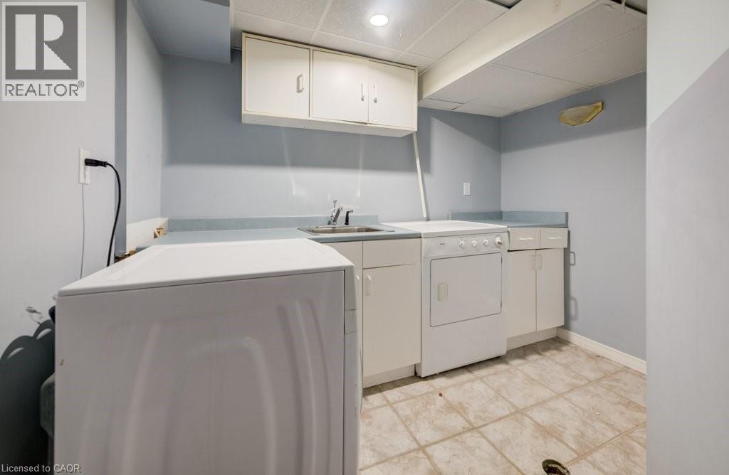 Washroom featuring a drop ceiling, cabinet space, and independent washer and dryer - 54 Nicklaus Drive, Hamilton, ON - Indoor Photo Showing Laundry Room