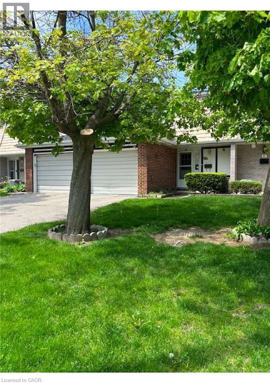 Brick and siding exterior featuring two garage doors and a covered entryway - 54 Nicklaus Drive, Hamilton, ON - Outdoor