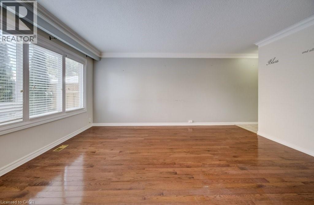 Unfurnished room with crown molding, hardwood / wood-style floors, and a textured ceiling - 54 Nicklaus Drive, Hamilton, ON - Indoor Photo Showing Other Room