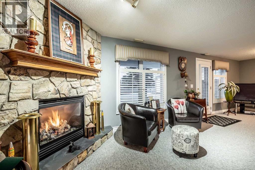 Custom stone facing gas fireplace - 509 Highview Point Nw, High River, AB - Indoor Photo Showing Living Room With Fireplace