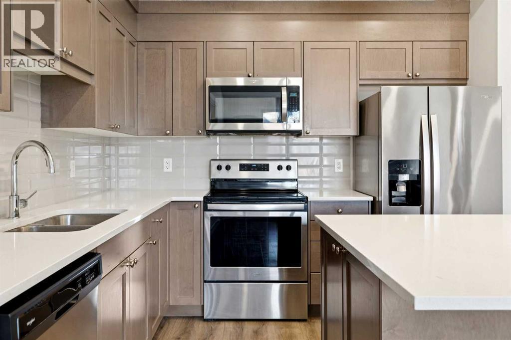 208, 30 Shawnee Common Sw, Calgary, AB - Indoor Photo Showing Kitchen With Stainless Steel Kitchen With Double Sink With Upgraded Kitchen