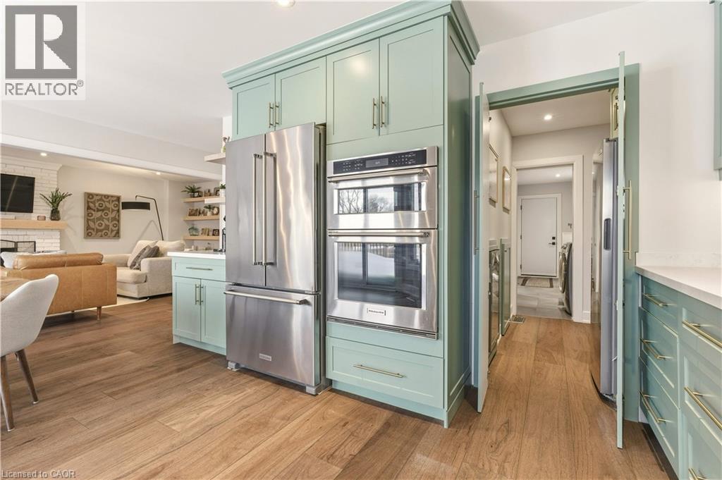 Kitchen featuring green cabinets, stainless steel appliances, open floor plan, recessed lighting, and light wood-style flooring - 697 Lambshead Drive, Burlington, ON - Indoor Photo Showing Kitchen