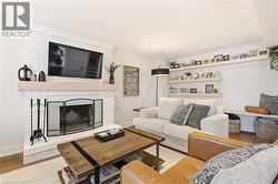 Living area with wood finished floors and a brick fireplace -