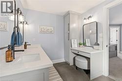 Bathroom featuring double vanity and dark tile patterned flooring -