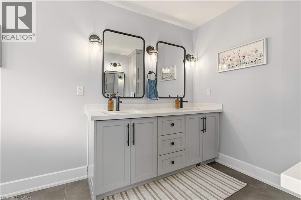 Bathroom featuring double vanity and baseboards - 697 Lambshead Drive, Burlington, ON - Indoor Photo Showing Bathroom