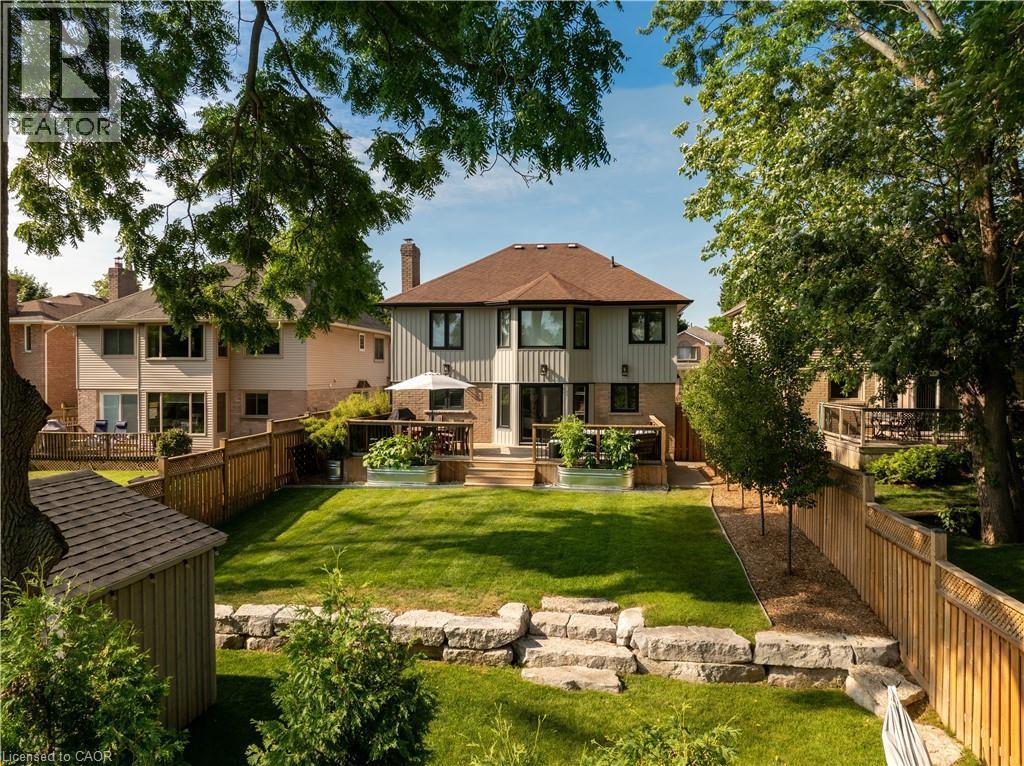 Back of property featuring a fenced backyard, a wooden deck, and brick siding - 697 Lambshead Drive, Burlington, ON - Outdoor With Deck Patio Veranda With Backyard