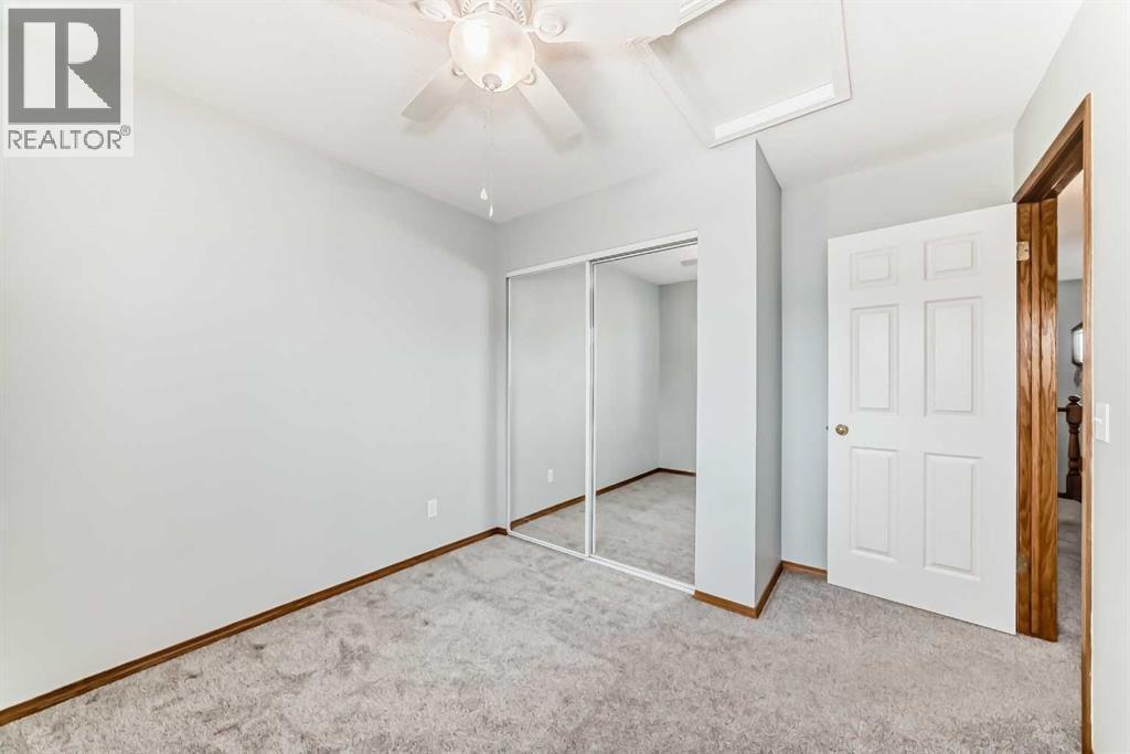 Bedroom 2 with closet and ceiling fan - 21 Hillview Road, Strathmore, AB - Indoor Photo Showing Other Room