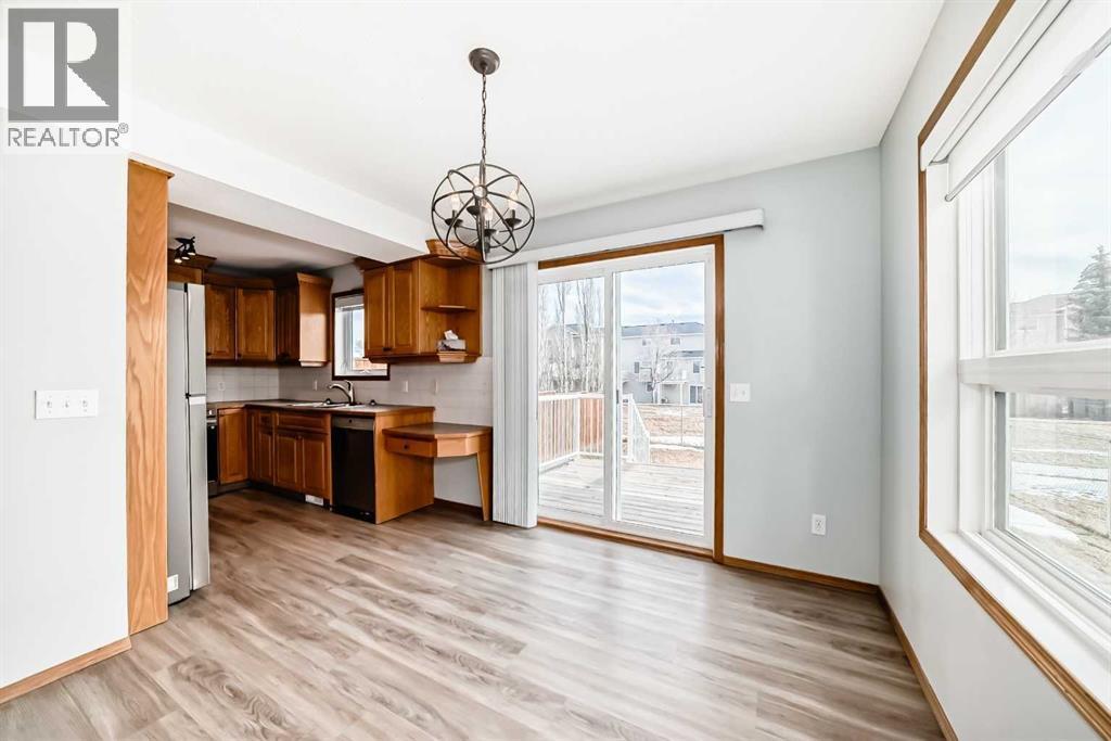 Dining room with the sliding glass doors to large deck and fenced back yard - 21 Hillview Road, Strathmore, AB - Indoor